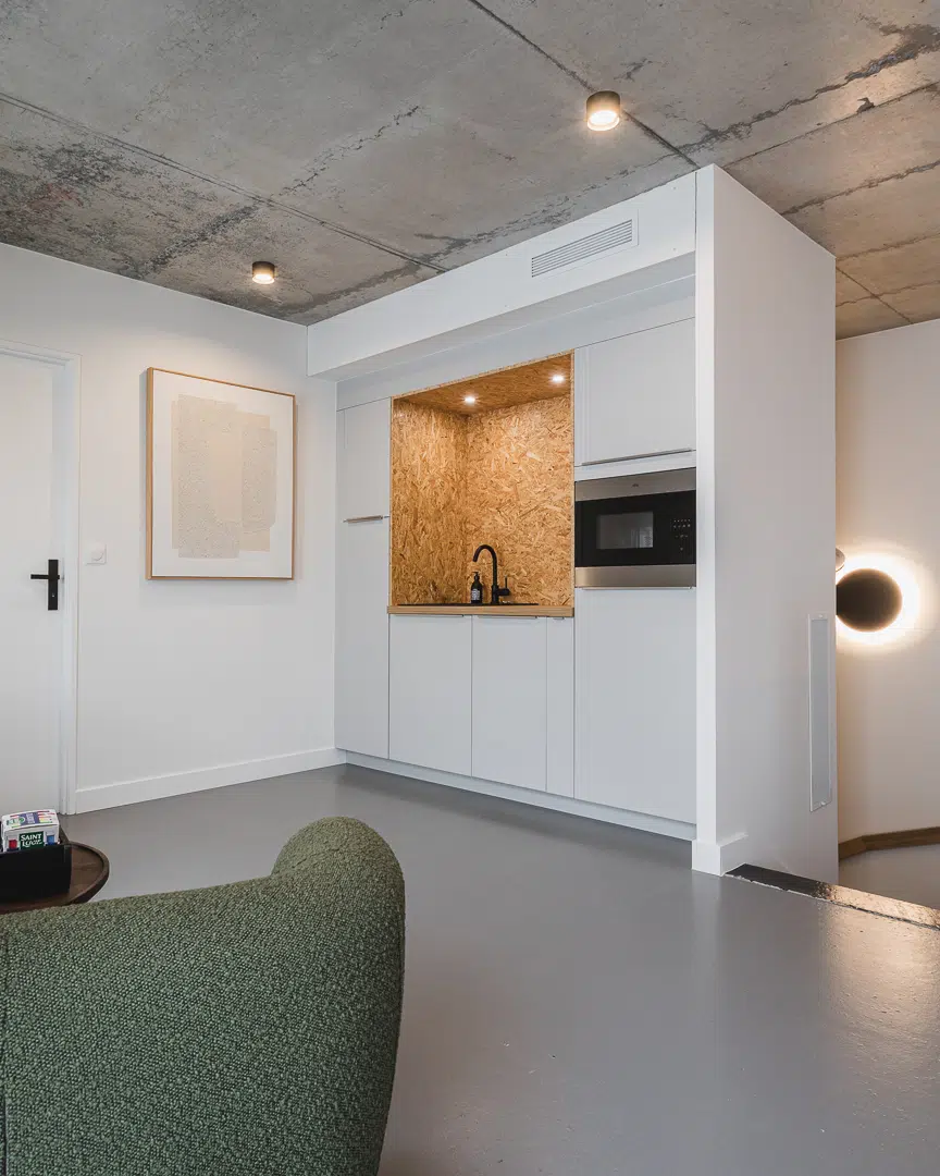 Petite cuisine ouverte en OSB et bois intégrée dans des bureaux professionnels à Plouharnel
