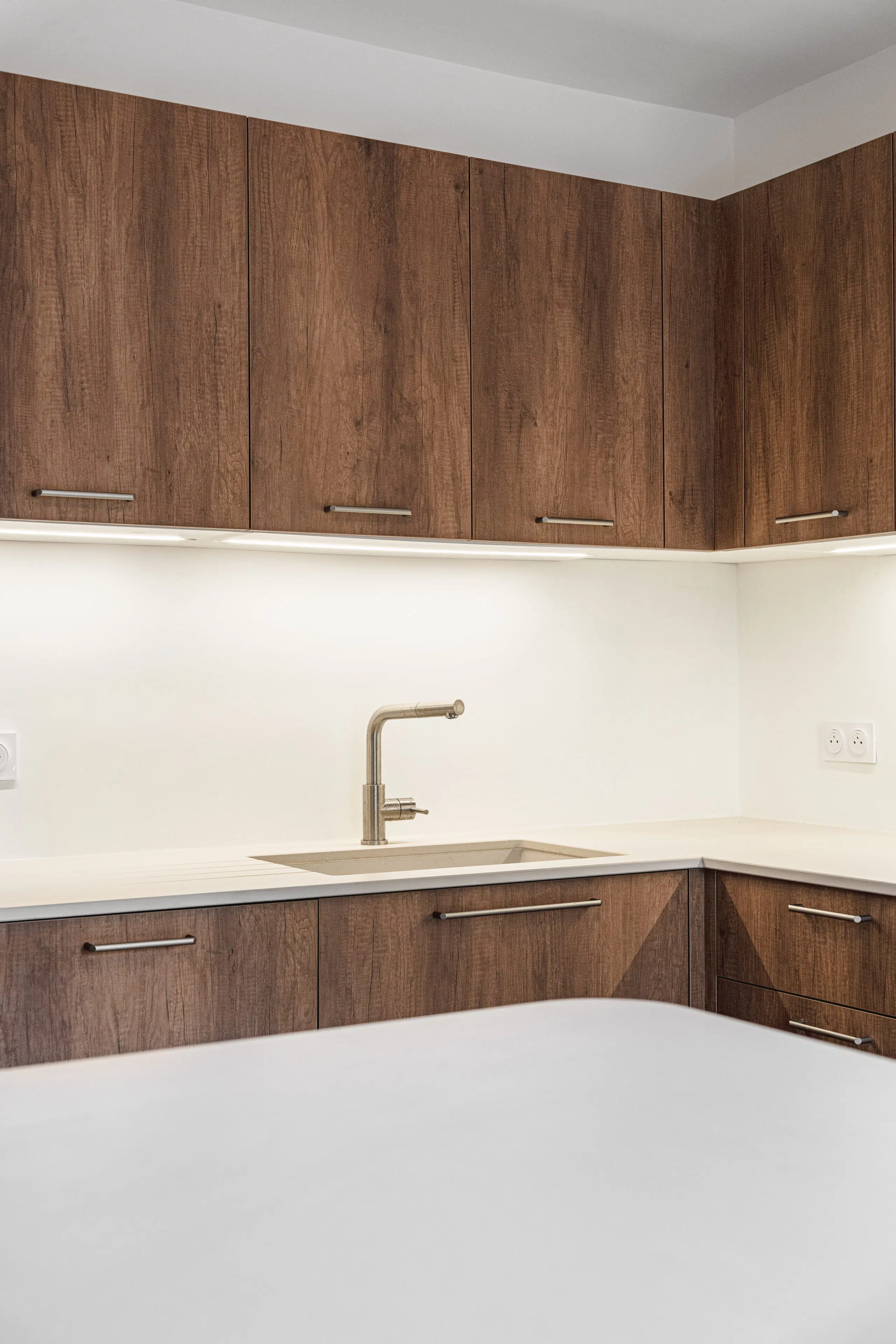 Warm Balance : cuisine sur mesure aux façades effet bois et plan clair, réalisée par Inside