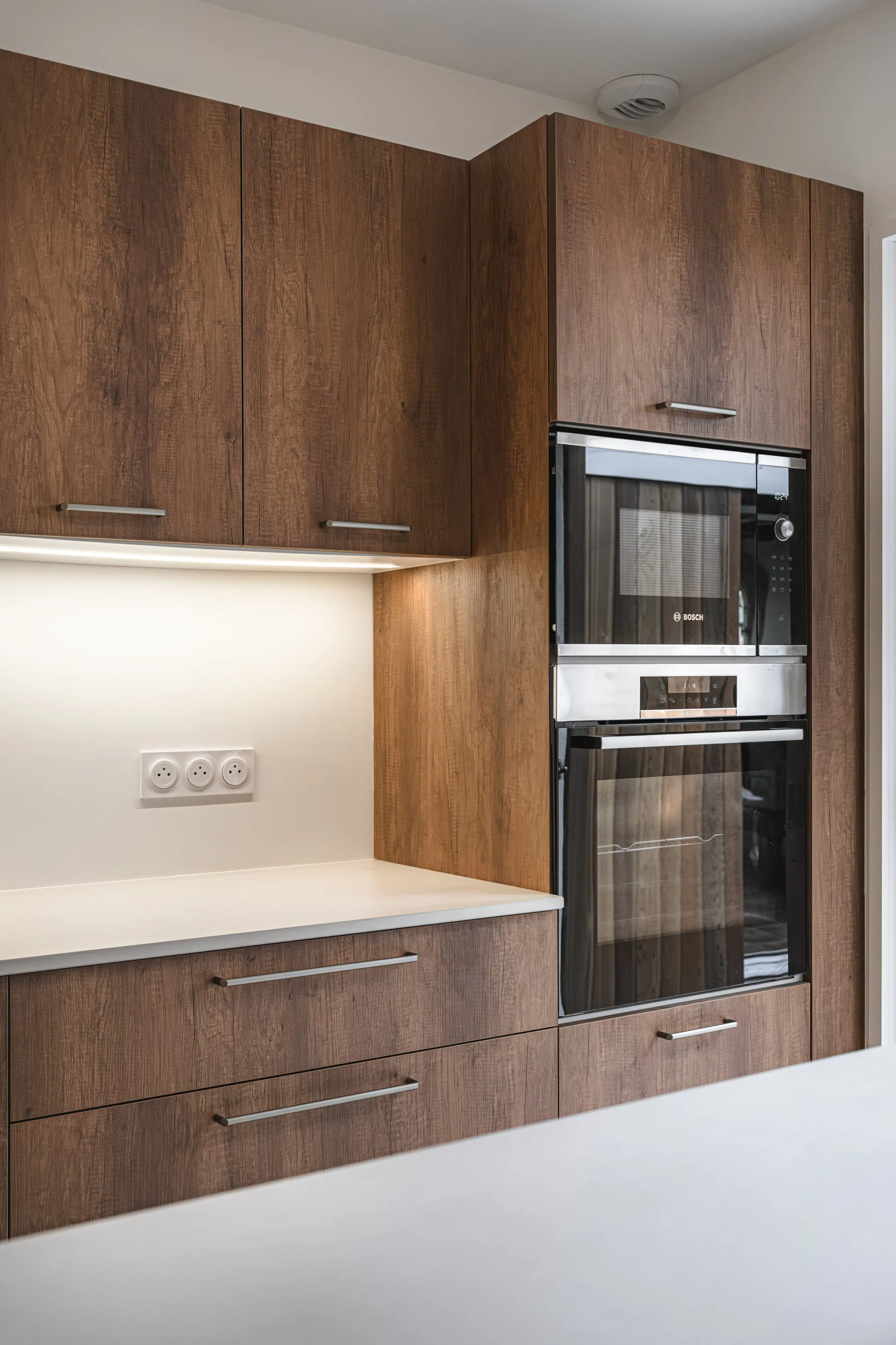 Warm Balance : cuisine sur mesure aux façades effet bois et plan clair, réalisée par Inside