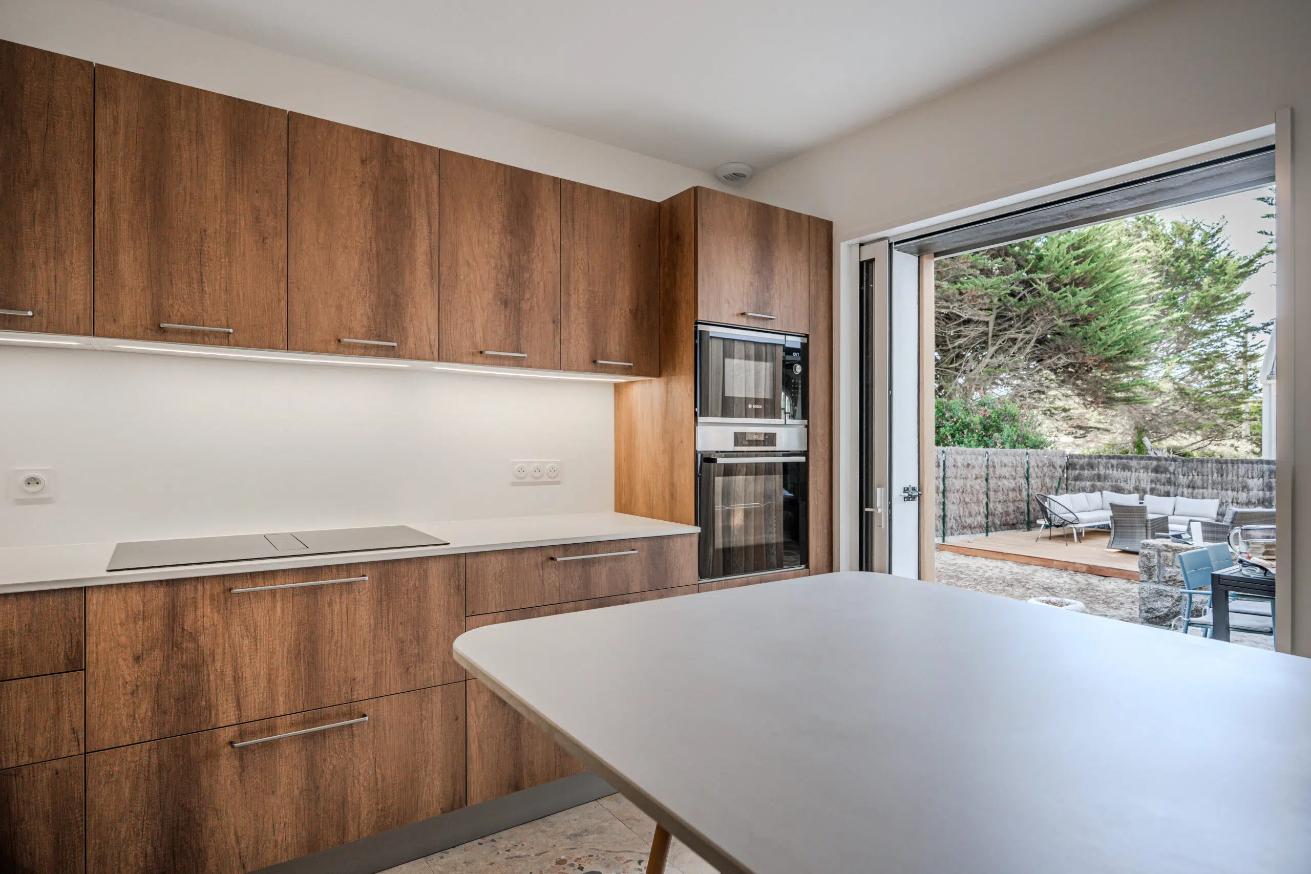 Warm Balance : cuisine sur mesure aux façades effet bois et plan clair, réalisée par Inside