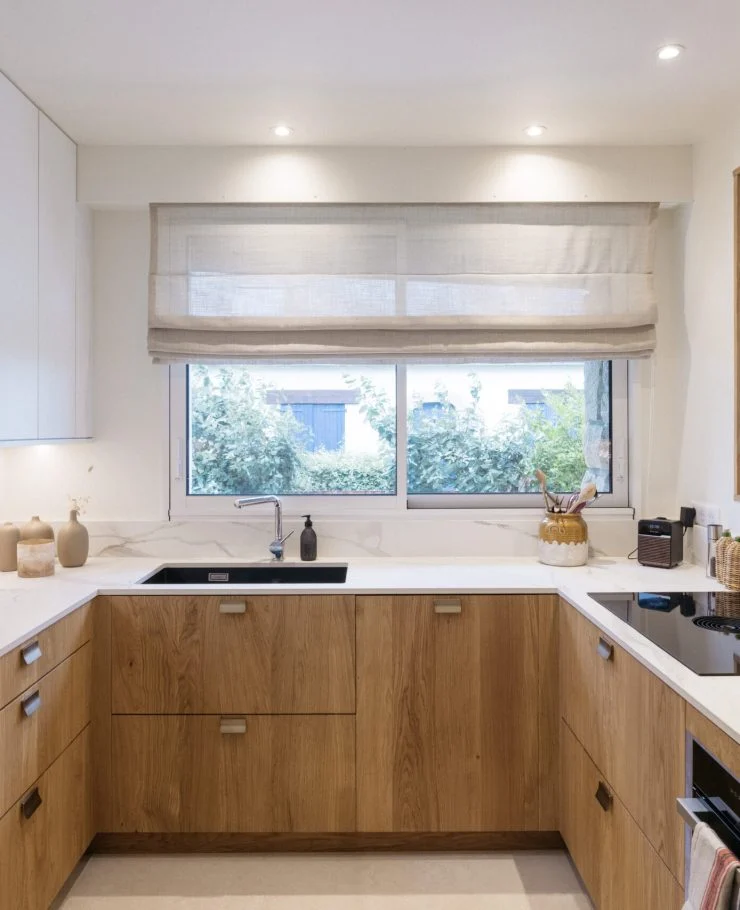 Petite cuisine en U en chêne massif et céramique Calacatta Oro dans une maison de Carnac