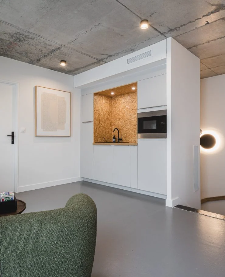 Petite cuisine ouverte en OSB et bois intégrée dans des bureaux professionnels à Plouharnel