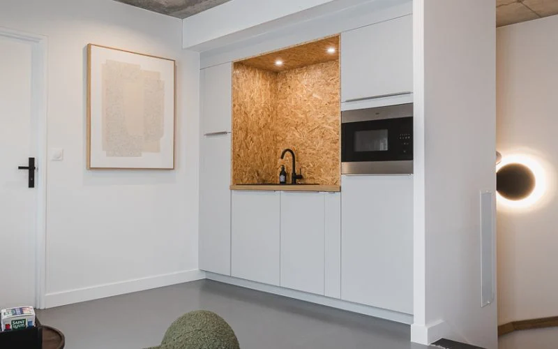 Petite cuisine ouverte en OSB et bois intégrée dans des bureaux professionnels à Plouharnel