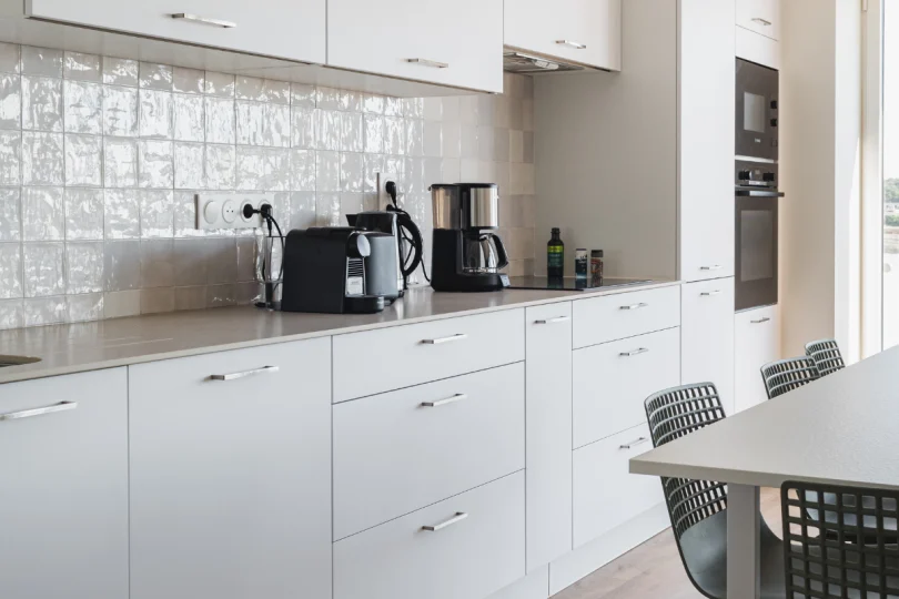 Cuisine en longueur ouverte sur la pièce de vie, plan en céramique Dekton, dans un appartement de location