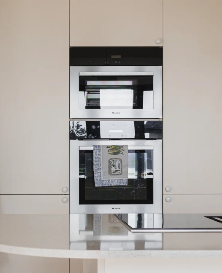 Cuisine ouverte tournée vers la mer, plan en quartz Silestone, finitions magnolia et chêne sauvage
