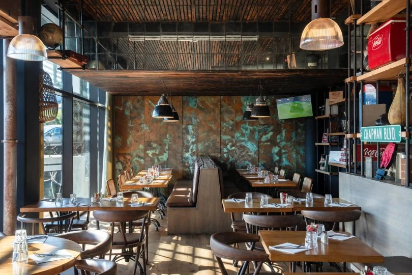 Bar-restaurant CDE à Auray : panneaux peints, moto suspendue et agencement végétal